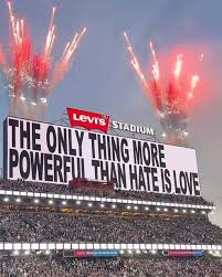 A banner reading The Only Thing More Powerful Than Hate is Love from Bad Bunny's Superbowl show